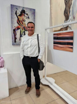 Dimitrios in fron of his artworks at Fire woman and sea exchibition
